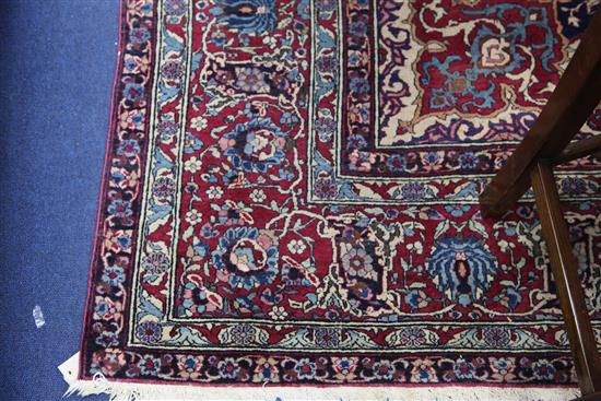 A Persian red and blue ground carpet. 9ft 10in by 7ft 2in.